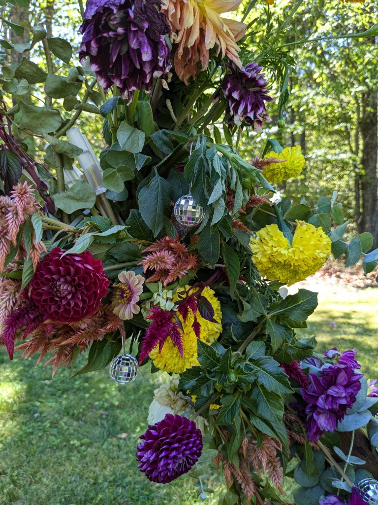 flower arrangement with small disco balls hanging in it