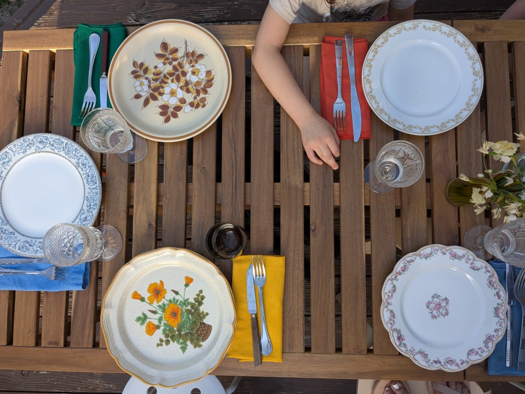 an overhead photo of vintage place settings on a wood table